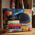 Bolso tote acolchado con gato negro dormido sobre pila de libros y taza, formato ancho